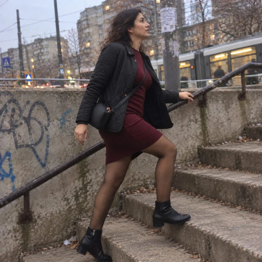 Femeie în colanți și rochie, pe scări